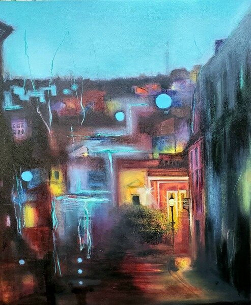 Painting of city at dusk Looks like seeing through a rainy window Buildings close together greens and purples and blacks One yellow doorway lit by street lamp 