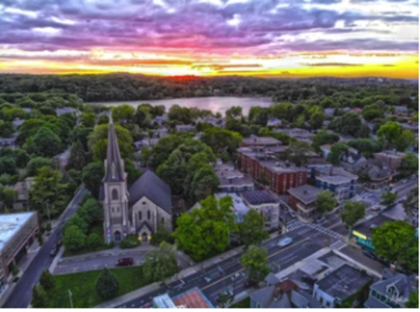 Sunset over Jamaica Plain View of Centre Street at corner of Myrtle Street looking at First Baptist Church as seen from arial drone 