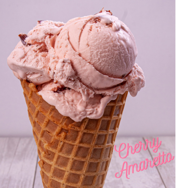 Pink ice cream with pieces of cherries on waffle cone in front of white background Pink text in lower right corner Cherry Amaretto