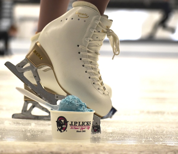 World039s Swirl Ice Cream blue colored,small scoop with spoon in small cup on ice rink with white ice skate behind it.